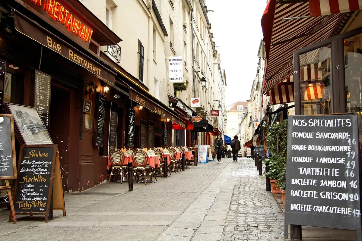 Restaurant and shop frontages lining Rue Mouffetard in Paris