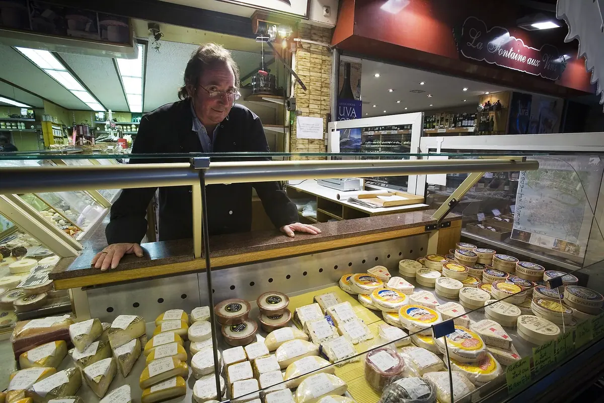 A cheese seller at a market stall on Rue Mouffetard in Paris